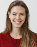 Uma jovem mulher amigável com um sorriso caloroso posa para um retrato profissional, transmitindo confiança, acessibilidade e energia positiva.
