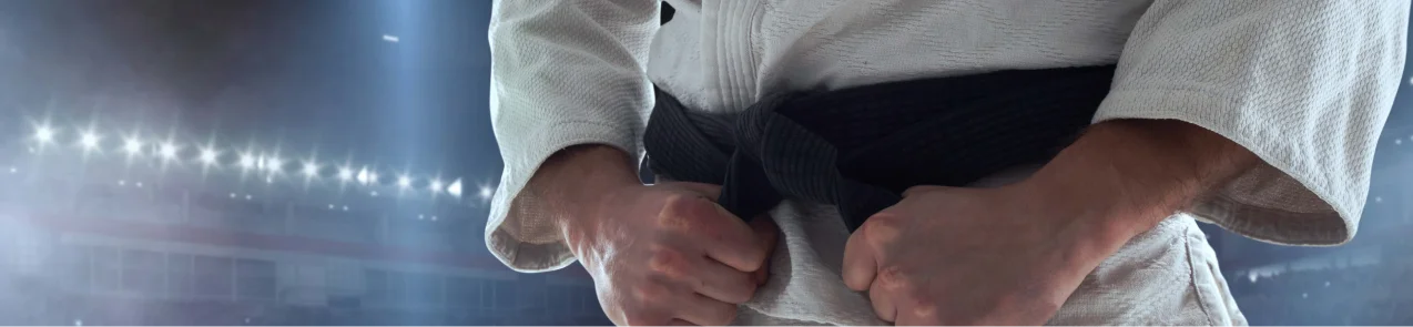 Uma visão de perto de um artista marcial se preparando para o treino ou competição, destacando foco, determinação e as tradições do karatê e das artes marciais.