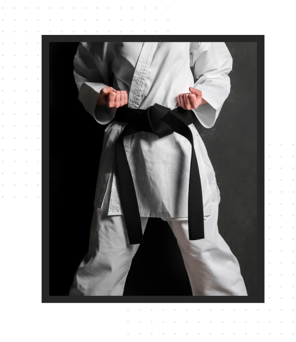 Um artista marcial está em uma posição de prontidão, vestindo um uniforme tradicional de karatê e um cinto preto, simbolizando dedicação, disciplina e domínio das artes marciais.