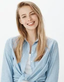 Uma jovem mulher alegre sorri naturalmente em um retrato de estúdio, representando profissionalismo, simpatia e comunicação empresarial moderna.